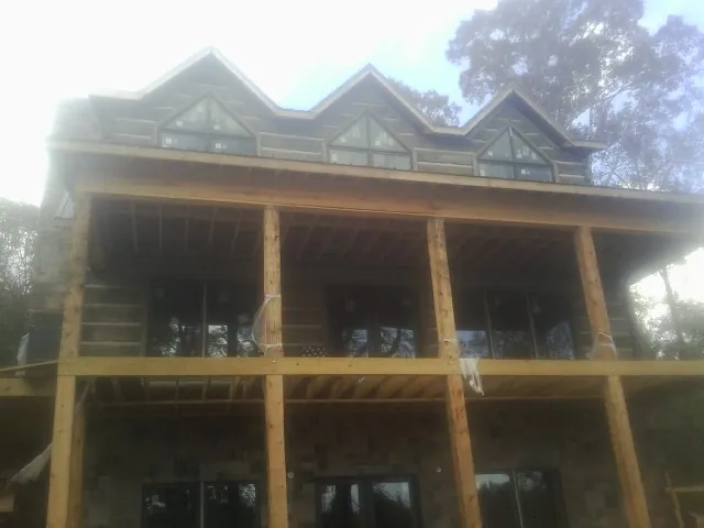 Dormers and porch framing on a large log home under construction — Roof Coating work by our crew in Peshastin